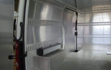 Vandttæt og hygiejnisk aluminiumsbeklædning på sider, døre og loft. Isolerede sider og loft. Baghjulskasser beklædt med aluriskornsplade og radiator monteret over disse.